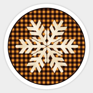 Snowflake silhouette over a black and orange tile pattern Sticker